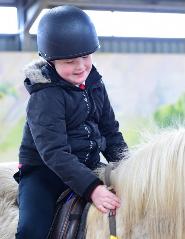 Cinders - boy patting her on horseback